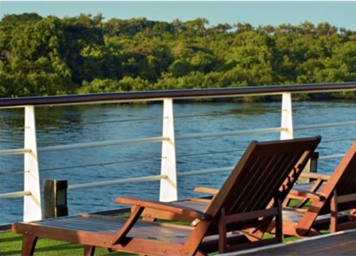 Iberostar Grand Amazon - Vista serena do rio com espreguiçadeiras em um deck de madeira